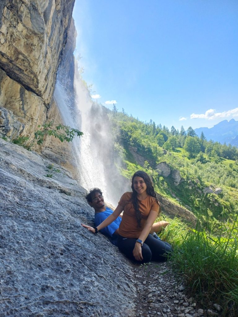 Deux campeurs assis sur les rochers au pied d'une cascade de montagne