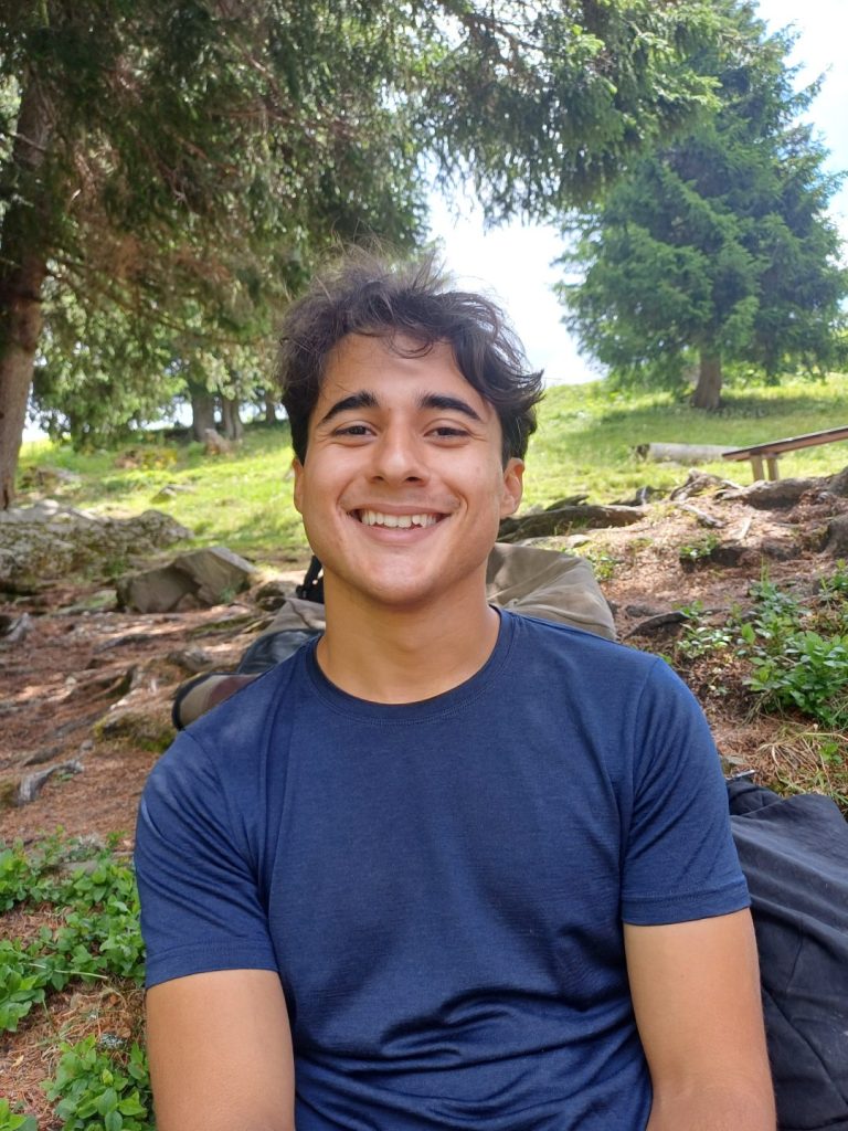 Monitrice souriante assise dans la forêt au camp d'été