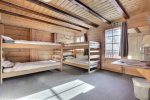 Dortoir avec lits superposés en bois au Chalet Budokan, chalet du camp juniors aux Diablerets