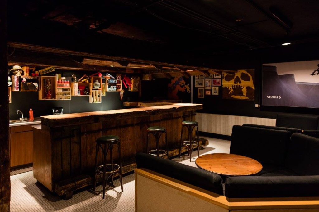 Salon et coin bar avec canapés et comptoir en bois au Chalet Budokan
