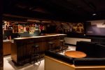 Salon et coin bar avec canapés et comptoir en bois au Chalet Budokan