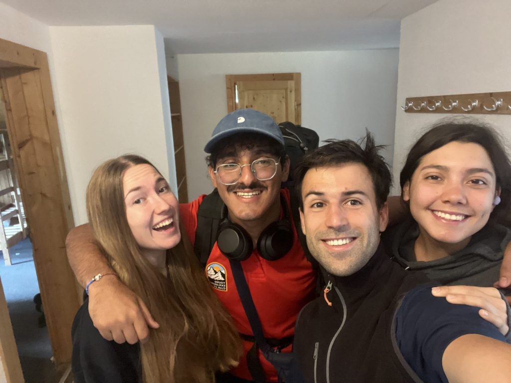 Quatre moniteurs Young Explorers Club souriants dans le couloir du chalet
