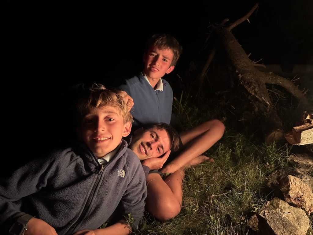 Deux campeurs allongés dans l'herbe près du feu de camp par une nuit d'été