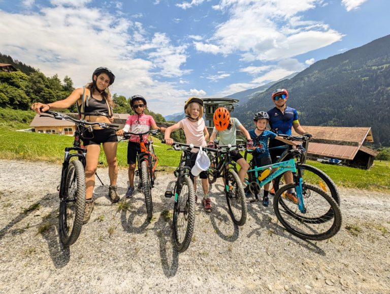 Instructor and campers with their mountain bikes on a gravel road in the Swiss Alps