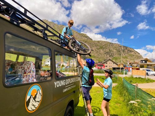 Campers loading their bikes onto the roof rack of the Young Explorers Club van