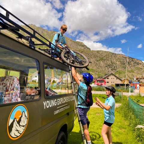 Campers loading mountain bikes onto the roof rack of the Young Explorers Club van