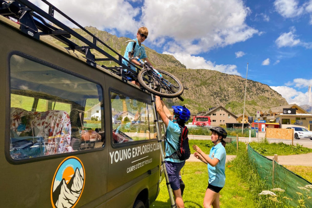 Campers loading mountain bikes onto the roof rack of the Young Explorers Club van