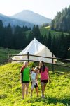 Campeurs devant une tente tipi sur un alpage en Suisse