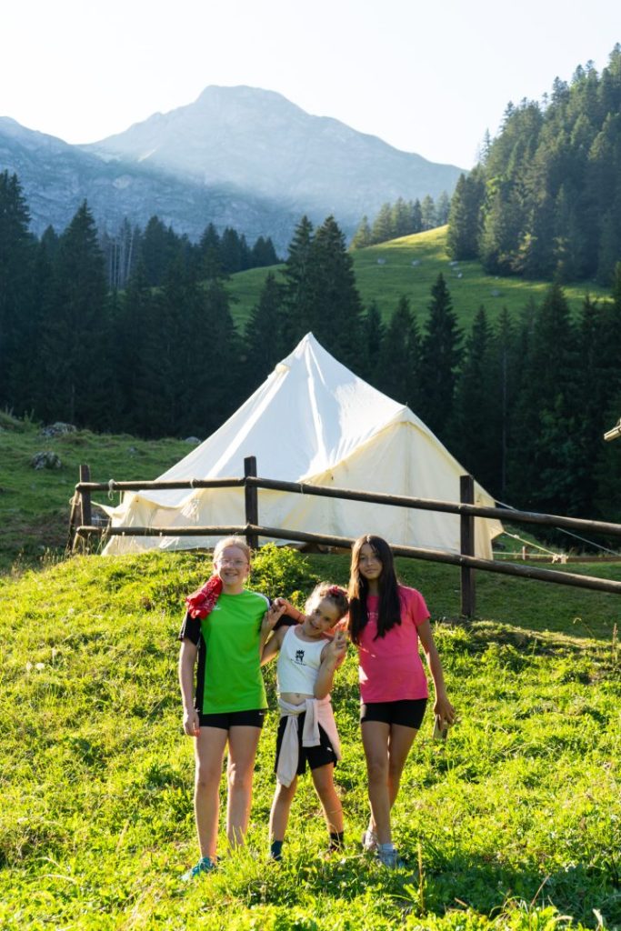 Campeurs devant une tente tipi sur un alpage en Suisse