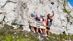 Aerial view of the climbing group holding the Young Explorers Club banner on the rock face