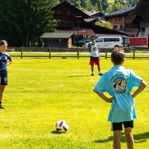 Coach leading a football drill on the pitch in Les Diablerets