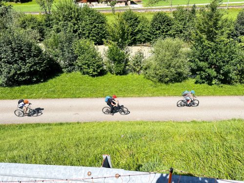 Family riders following a gravel cycle path through the valley on the Family Bike Travel Camp