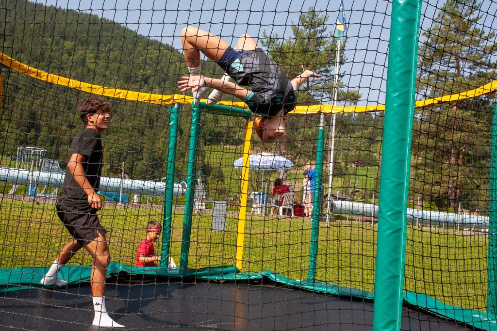 Camper doing a backflip on a trampoline at summer camp