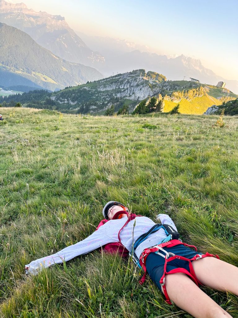 Camper lying flat out in the grass on a high alpine meadow