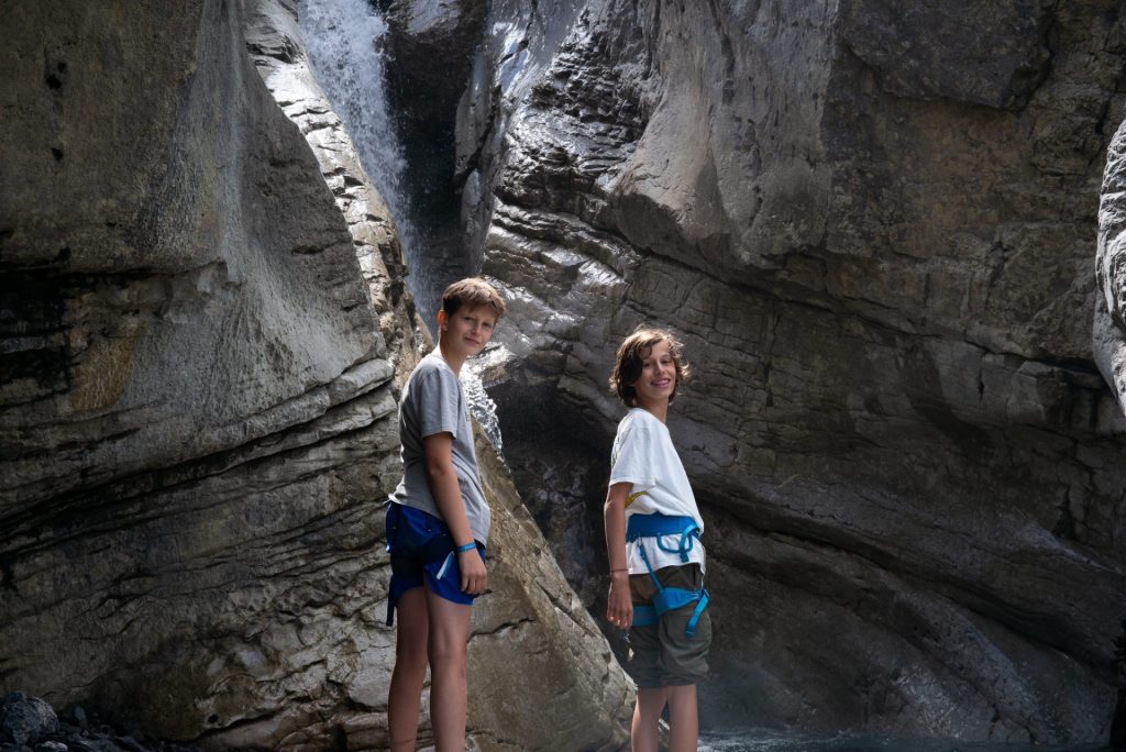 Deux campeurs explorant une gorge étroite avec une cascade