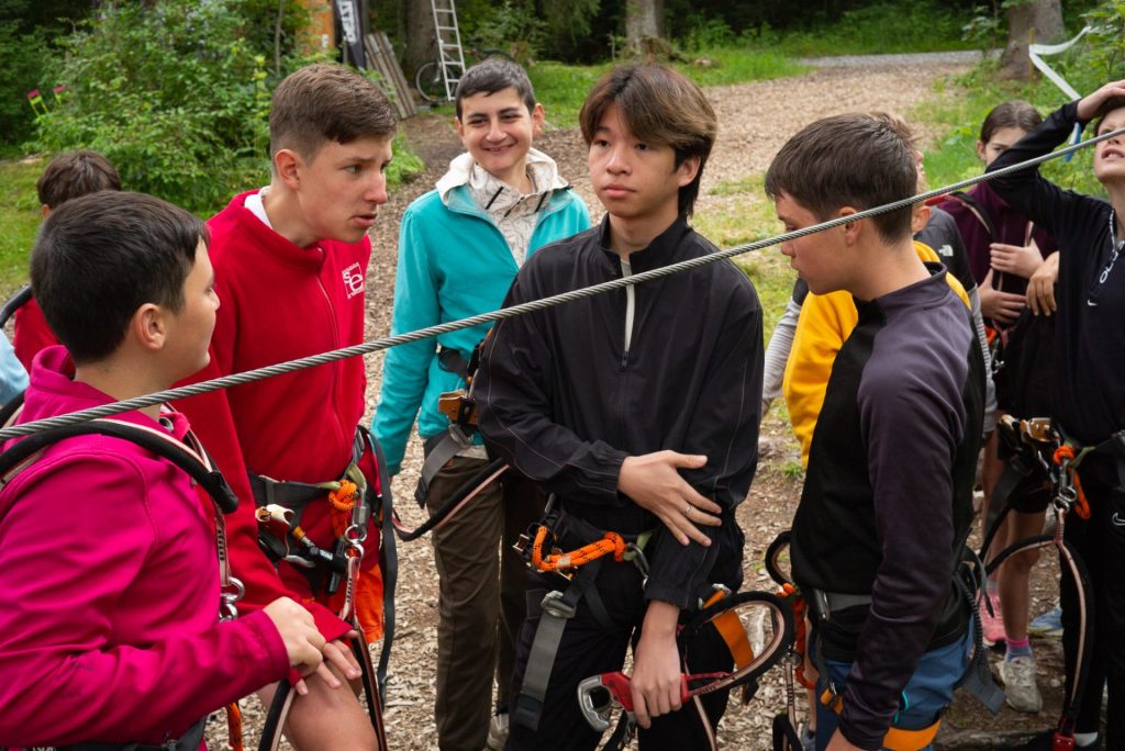 Ados en baudrier écoutant le briefing de sécurité au parc aventure
