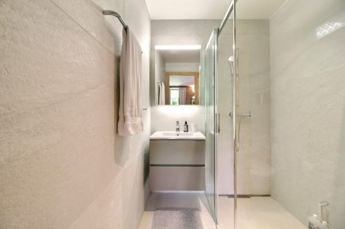 Modern bathroom with a glass shower and washbasin in the family camp chalet in Champéry
