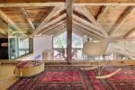 Coin salon sous les combles avec fauteuil à bascule et tapis au chalet de Champéry