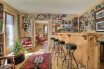 Salon avec bar en bois, tabourets et photos encadrées au chalet du camp familial