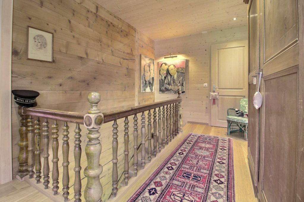 Palier de l'étage avec rampe en bois et tapis au chalet de Champéry
