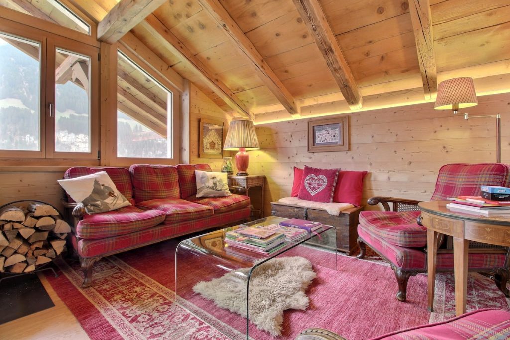 Salon chaleureux avec canapés rouges et poêle à bois au chalet du camp familial