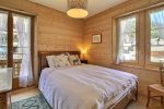 Bedroom with a double bed and bright windows in the Champéry chalet