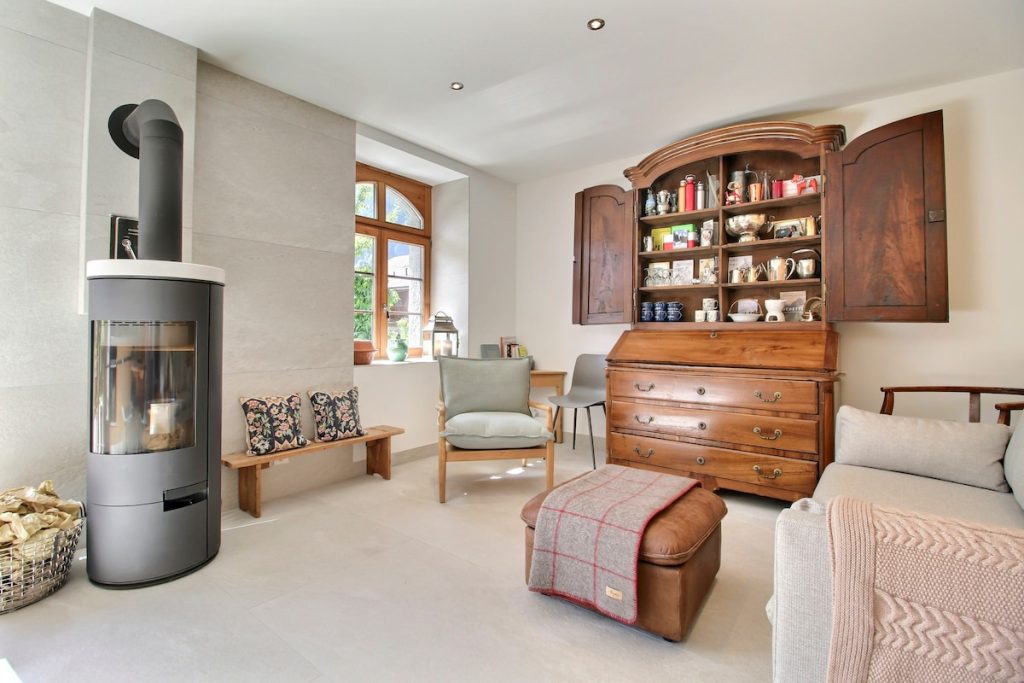 Petit salon avec poêle à bois et vaisselier ancien peint au chalet de Champéry