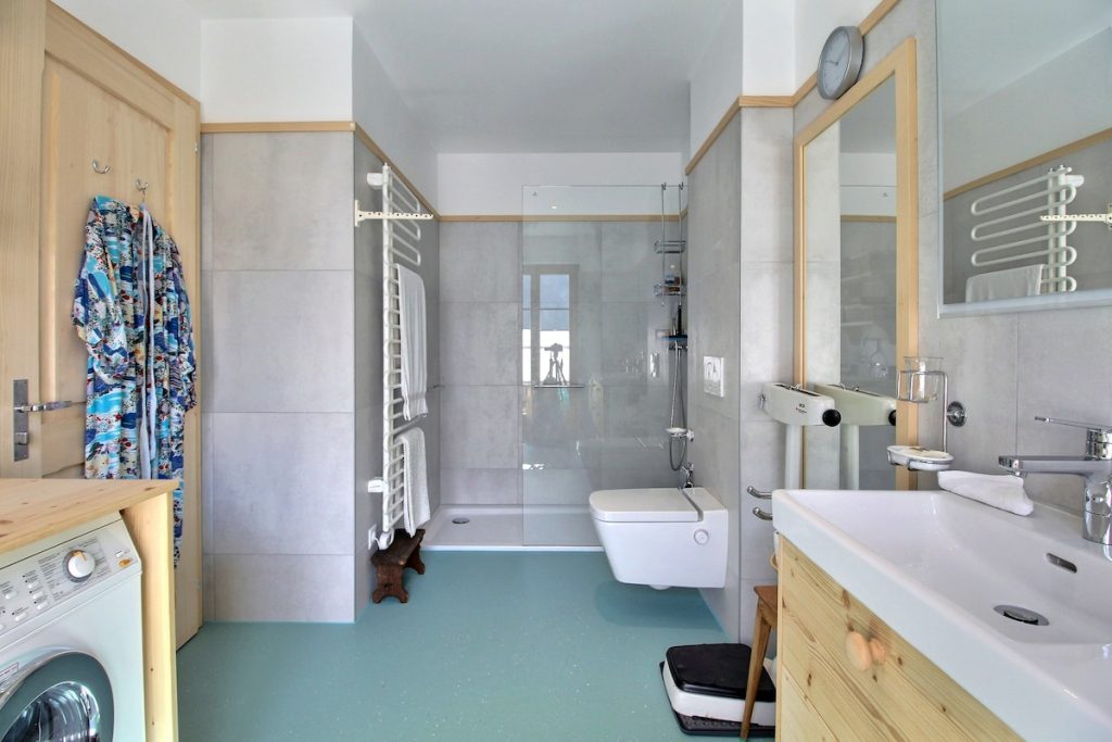 Salle de bains avec douche, lavabo et lave-linge au chalet du camp familial