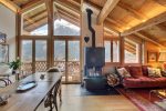 Salon avec poêle à bois, table à manger et vue sur les montagnes au chalet de Champéry