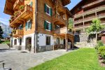 Balcons fleuris et terrasse en pierre du chalet du camp familial à Champéry