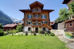 Chalet suisse traditionnel aux volets verts avec pelouse à Champéry, maison du Family Multi Adventure Camp